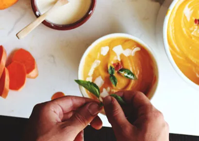 Frisch zubereitete Kürbissuppe mit Kürbisstücken und herbstlichen Zutaten – saisonale Rezeptidee für genussvolles Kochen in einer gut geplanten Küche.